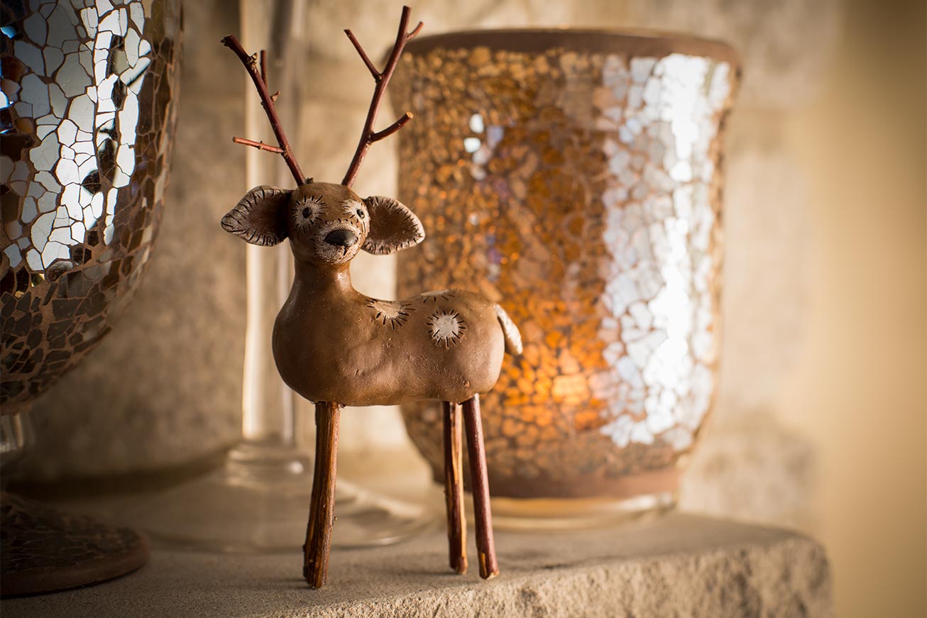 Handcrafted brown clay deer figurine with realistic details.