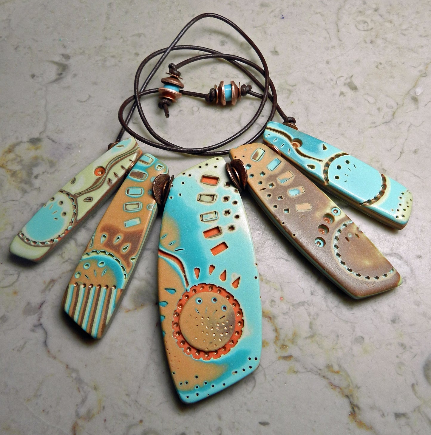 Turquoise and brown ceramic pendant necklace with abstract engraved designs