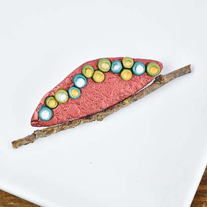 Handmade pendant using Liquid Sculpey dotting technique for detailed patterns.
