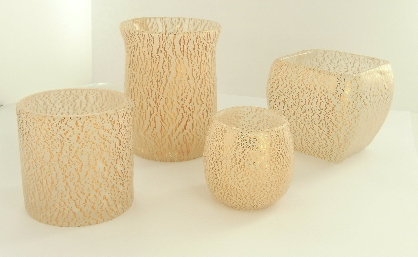 Assorted glass votive holders featuring crackle-textured metallic and cream polymer clay overlays for home decor.